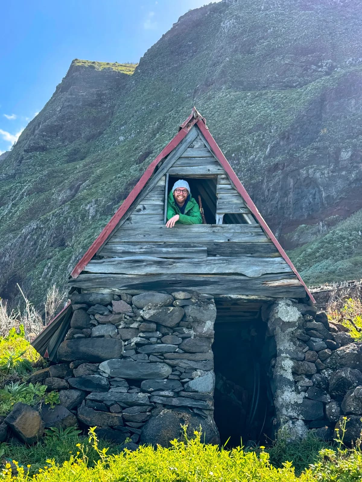 Team member smiling from a traditional Madeiran stone hut in the mountains